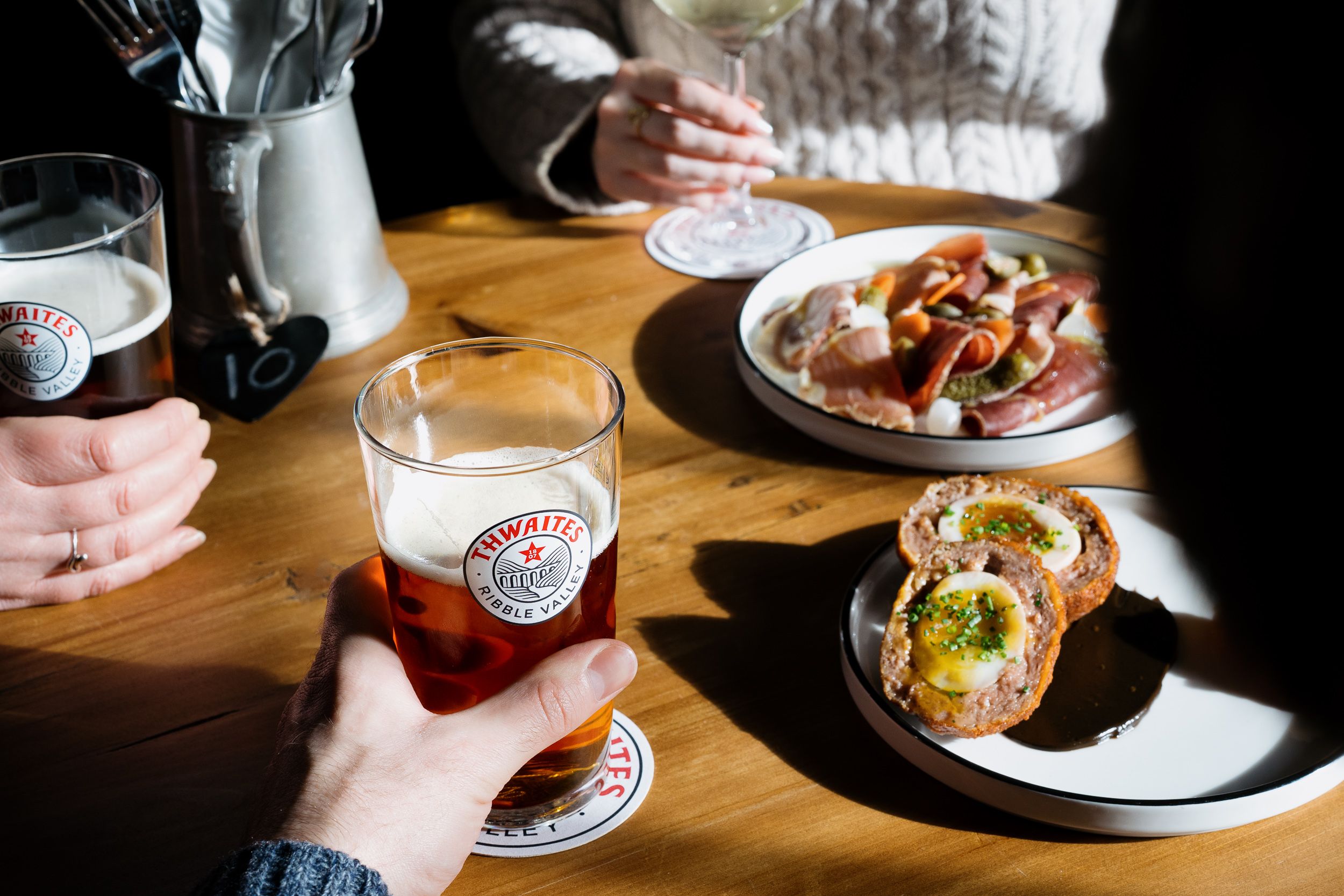 selection of small dishes and a pint of thwaites ale